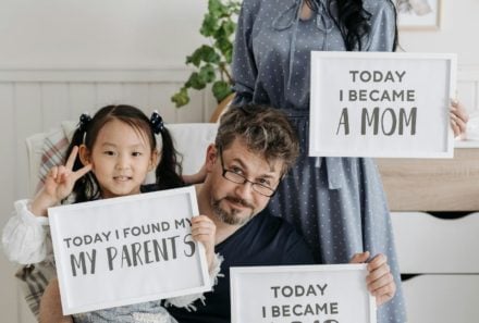 adoption family holding signs