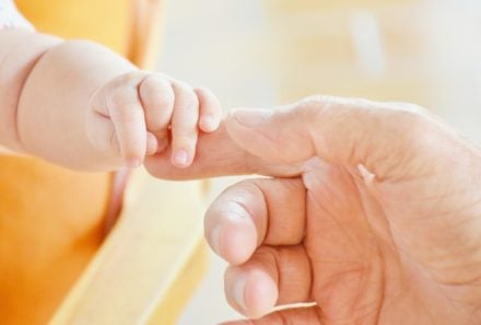 baby's hand holding parent's finger