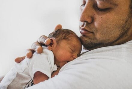 Adoptive father holding infant
