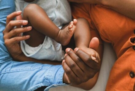 adoptive parents holding their baby's feet