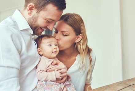 mother and father holding baby