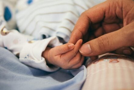 mom and baby holding hand